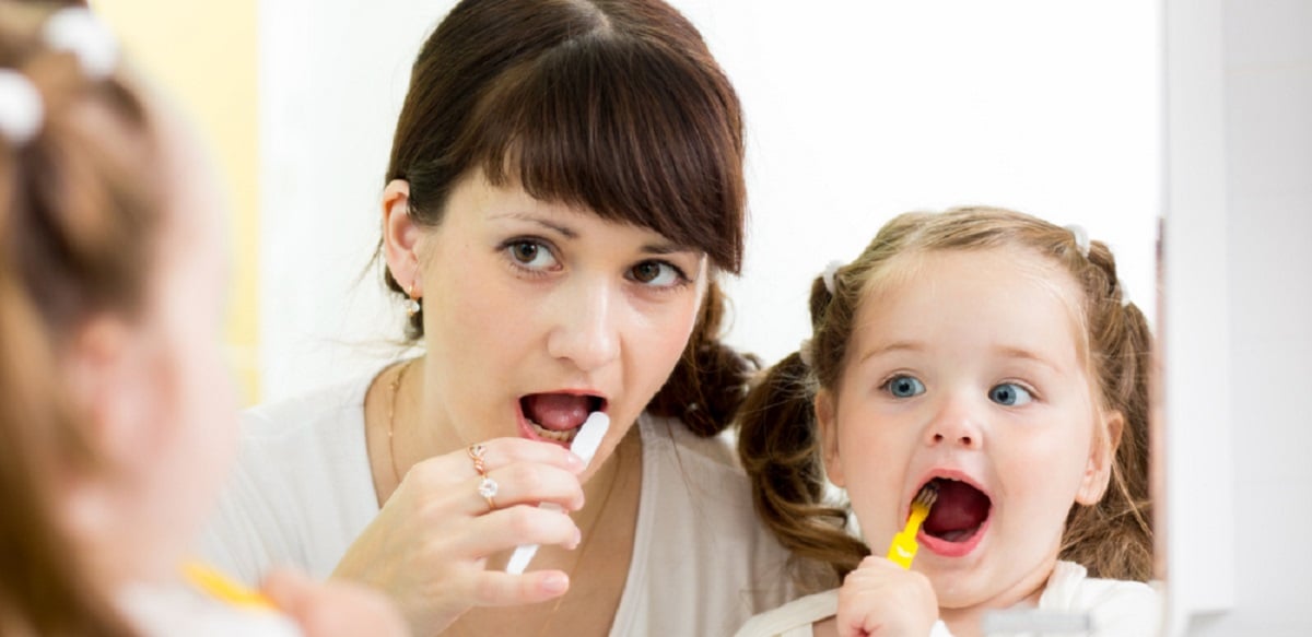 мама с девочкой чистят зубы