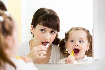 мама с девочкой чистят зубы